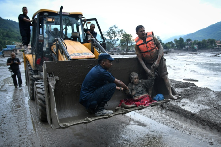 Les secouristes évacuent une personne ayant survécu à la crue soudaine à Devghat, dans le district de Nuwakot au Népal, le 26 août 2026 ( AFP / PRAKASH MATHEMA )