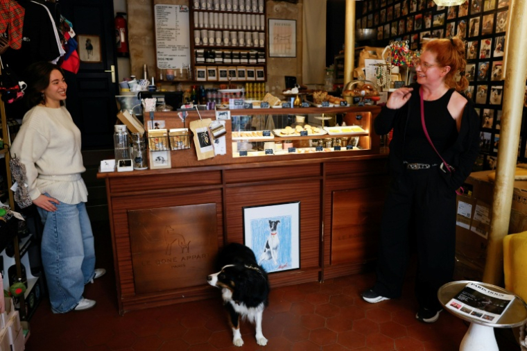 Rebecca Anhalt (d), propriétaire du café pour chiens "Le Bone Appart" et une membre de son personnel, le 7 mai 2026 à Paris ( AFP / Xavier GALIANA )