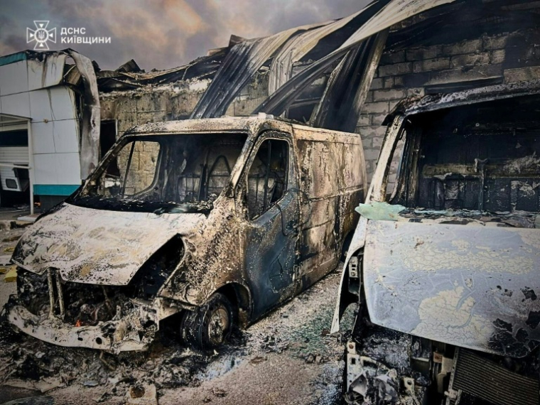 Photo diffusée par le service d'urgence de l'État ukrainien, le 18 mai 2025, de véhicules calcinés près d'un bâtiment civil après des attaques de drones russes sur la région de Kiev ( Service d'urgence de l'État ukrainien / Handout )
