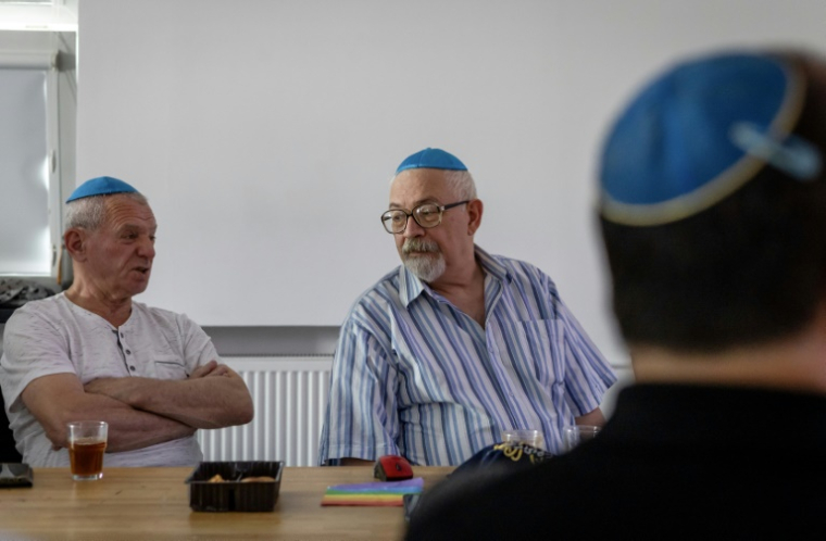 Vladimir Levin (C), un réfugié juif ukrainien de 67 ans, participe à une réunion du club pour seniors "Parlons-en", le 24 juillet 2025 au centre communautaire juif à Varsovie ( AFP / Wojtek RADWANSKI )