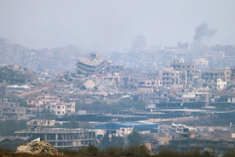 Une photo prise depuis la frontière israélienne avec la bande de Gaza montre dees destructions et de la fumée s'élevant au dessus du territoire palestinien après des raids israéliens, le 18 mai 2025 ( AFP / Menahem KAHANA )