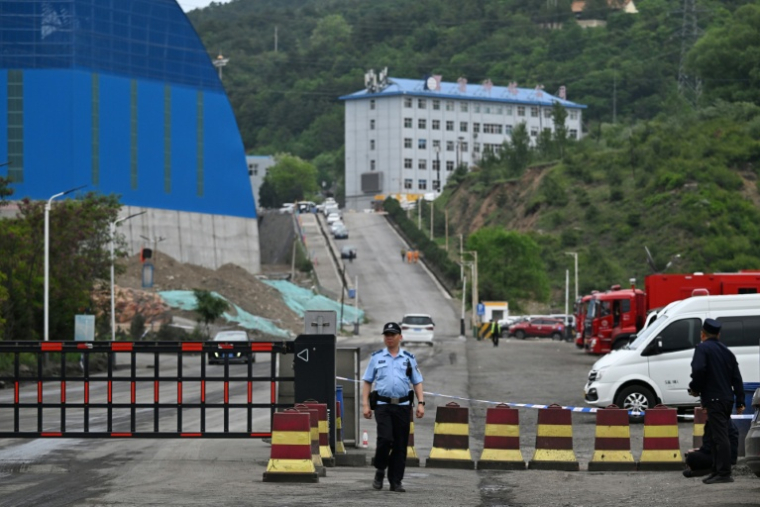 Un policier devant l'entrée de la mine de charbon de Liushenyu, où un coup de grisou dévastateur a fait au moins 82 morts, le 24 mai 2026 dans le district administratif de Qinyuan, dans la province chinoise septentrionale du Shanxi ( AFP / GREG BAKER )