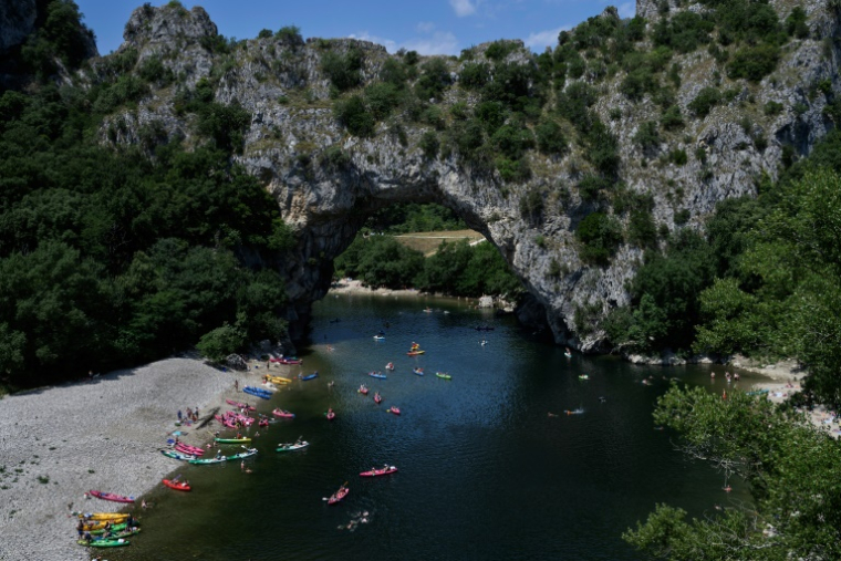 Des vacanciers en canoës et kayaks sur la rivière Ardèche près de Vallon-Pont-d'Arc, le 15 juillet 2025 en Ardèche ( AFP / JEAN-PHILIPPE KSIAZEK )
