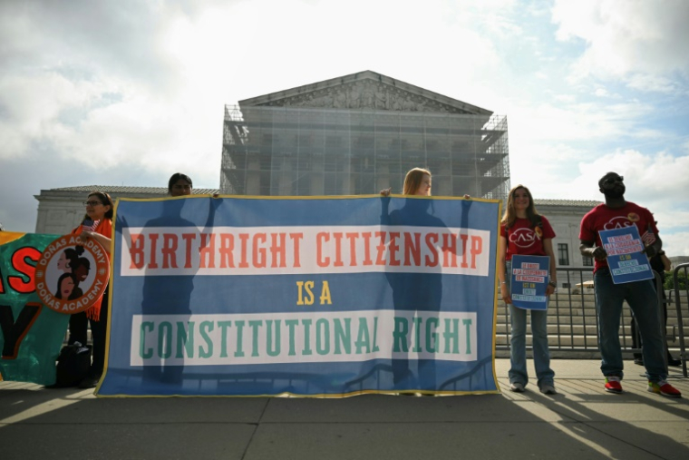 Des manifestants brandissent des pancartes en faveur du droit du sol aux Etats-Unis devant la Cour suprême, à Washington le 15 mai 2025 ( AFP / Drew ANGERER )