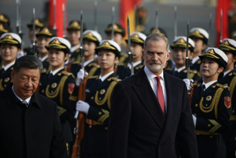 Le président chinois Xi Jinping (g) et le roi d'Espagne Felipe VI passent en revue la Garde d'honneur à Pékin, le 12 novembre 2025 ( POOL / ANDRES MARTINEZ CASARES )