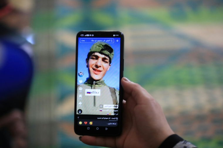 Une photo du jeune Irakien Mohammed Imad, publiée sur les réseaux sociaux après son départ pour se battre dans l'armée russe en Ukraine, visible sur un téléphone portable au domicile familial à Musayab, au sud de Bagdad, le 10 septembre 2025 ( AFP / Karrar Jabbar )
