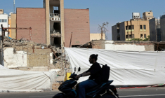 Un motocycliste passe devant le lycée Alameh Tabatabaei, détruit par une frappe aérienne américano-israélienne pendant la guerre, à Téhéran, le 3 mai 2026 ( AFP / - )