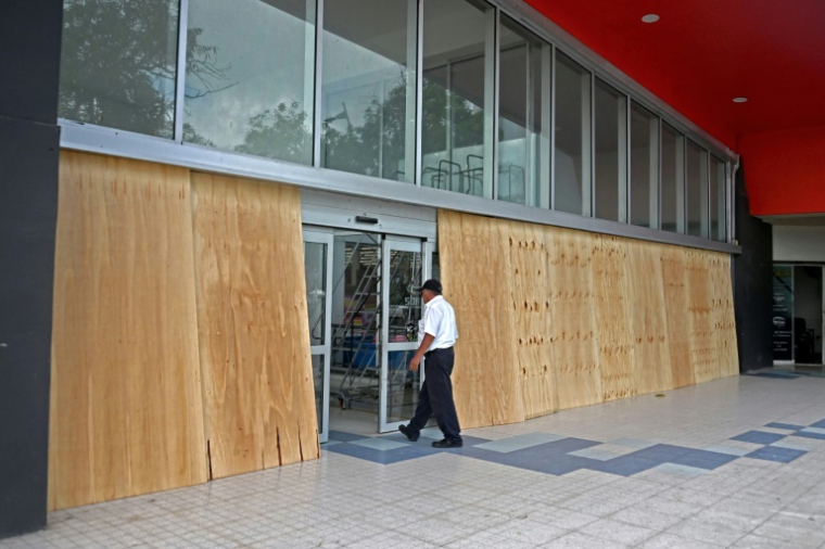 Des panneaux en bois installés devant les vitres d'une entreprise avant l'arrivée de l'ouragan Erick, le 18 juin 2025 à Acapulco, dans le sud du Mexique ( AFP / Francisco Robles )