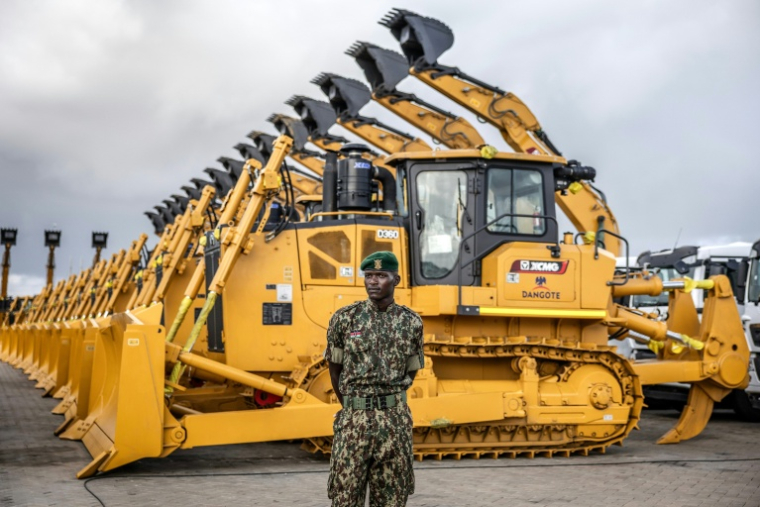 Un membre du Service national de la jeunesse (NYS) du Kenya surveille des excavatrices et autres machines lourdes avant une cérémonie d'inauguration d'une raffinerie de pétrole à Lamu (Kenya), le 30 septembre 2026 ( AFP / Luis TATO )