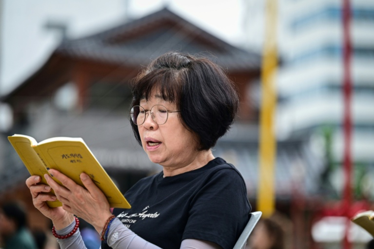 Cette photo prise le 2 juillet 2026 montre une femme priant au temple Jogyesa, à Séoul. ( AFP / Jade GAO )