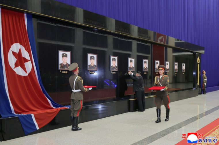 Photo prise le 12 décembre 2025 et diffusée le 13 décembre par l'agence de presse officielle nord-coréenne KCNA, montrant le dirigeant nord-coréen Kim Jong Un (c) remettant des médailles à titre posthume devant les portraits de soldats nord-coréens tués lors de leur déploiement à Koursk, en Russie, à la Maison de la Culture du 25 Avril à Pyongyang ( KCNA VIA KNS / STR )