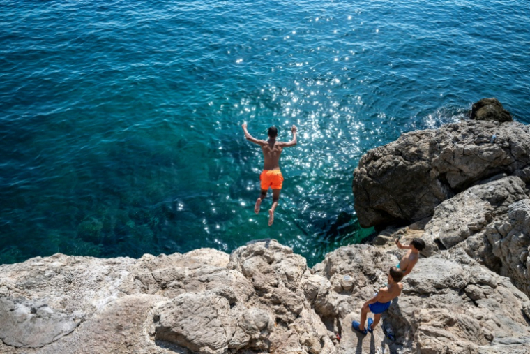 Un jeune saute de la corniche à Marseille le 11 août 2026 ( AFP / Miguel MEDINA )