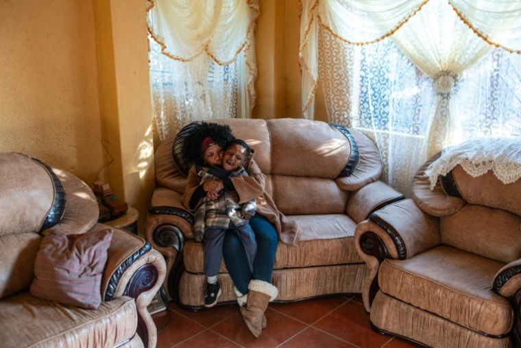 Baile Bantseke et son petit-fils Mphoentle, autiste, dans leur maison du quartier de Snake Park, à Soweto, le 23 mai 2025 en Afrique du Sud ( AFP / EMMANUEL CROSET )