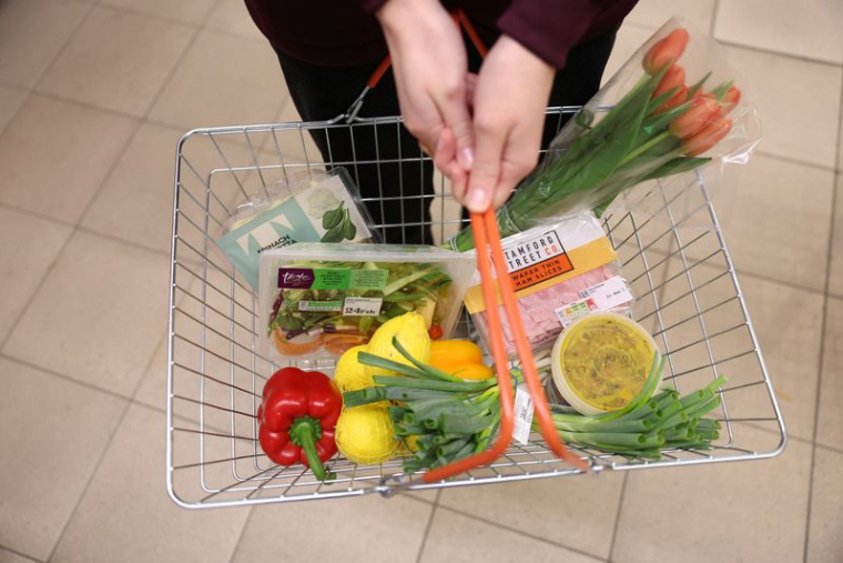 Un client porte un panier rempli de nourriture à l'intérieur d'un supermarché à Londres