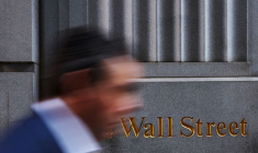 Un homme passe devant un marquage de Wall Street à l'extérieur du bâtiment de la Bourse de New York (NYSE) à New York City