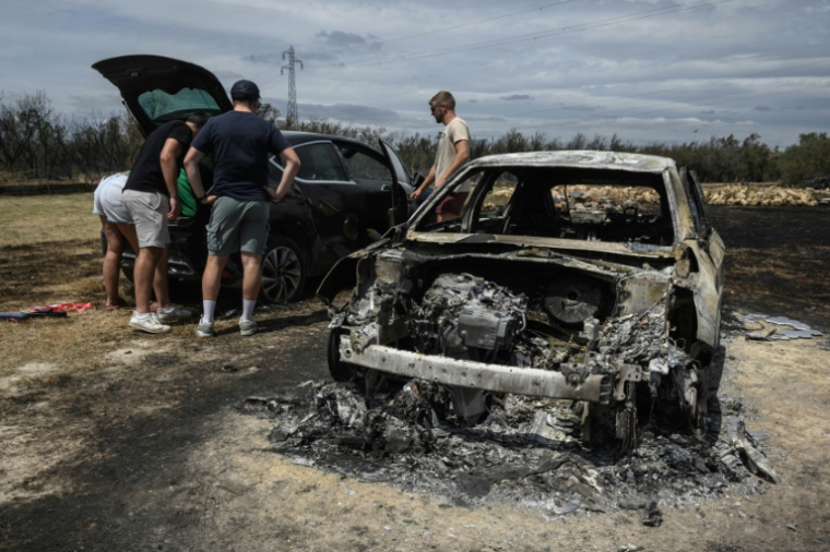 Une voiture brûlée dans le feu de forêt à Sigean (Aude) le 27 juillet 2025 ( AFP / Ed JONES )