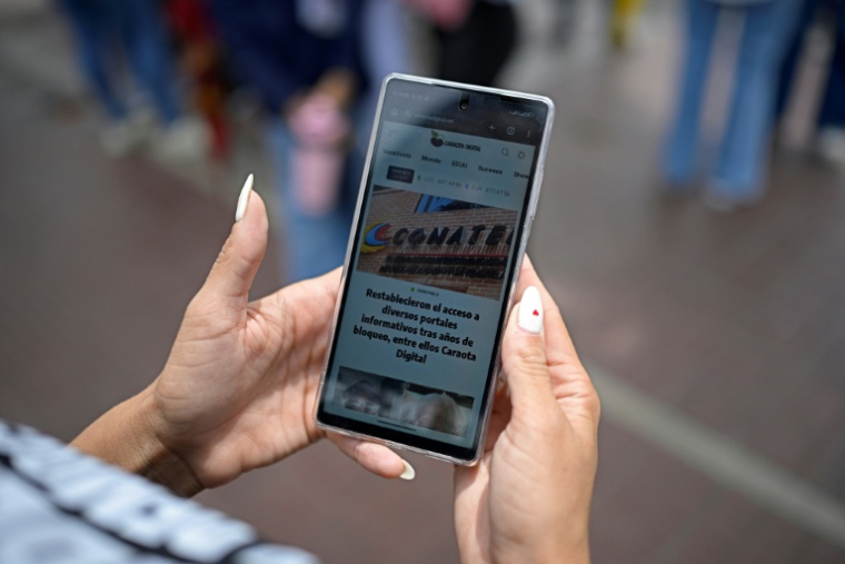 Une femme lit un article du site vénézuélien Caraota Digital à Caracas, le 17 septembre 2026 ( AFP / Federico PARRA )