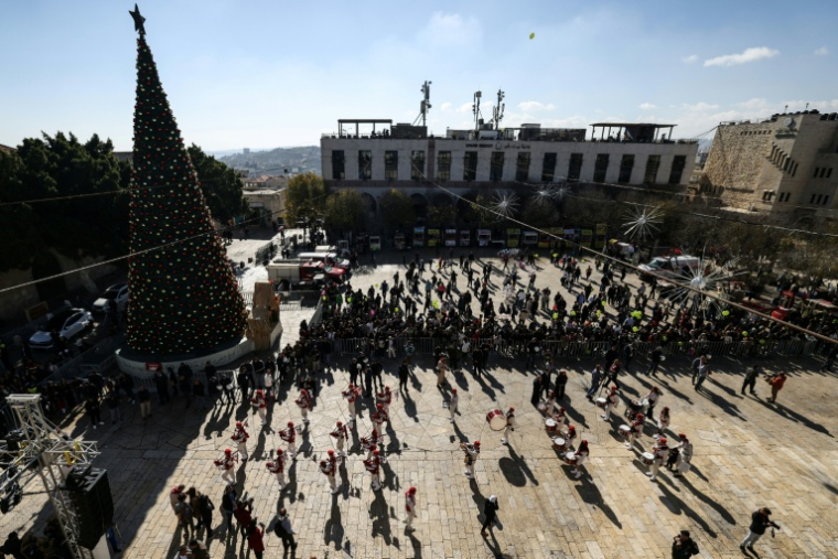 Une parade de scouts sur la place de la Mangeoire, devant la basilique de la Nativité à Bethléem, le 24 décembre 2025 en Cisjordanie occupée ( AFP / HAZEM BADER )