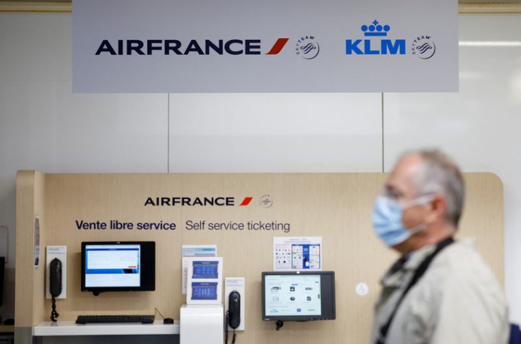 Un passager passe devant les logos Air France et KLM à l'aéroport de Nantes-Atlantique en France