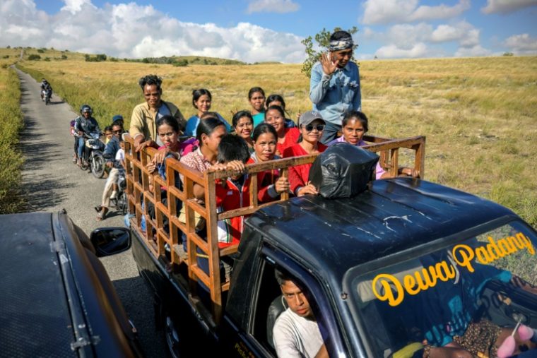 Des villageois à bord d'un camion sur une route du village de Tanggedu, sur l'île de Sumba, le 23 juin 2026 en Indonésie ( AFP / BAY ISMOYO )