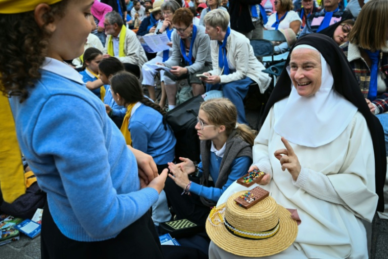 Une religieuse, des scouts et des fidèles à l'extérieur de la cathédrale Saint-Etienne de Metz, attendant le pape Léon XIV le 28 septembre 2026 ( AFP / SEBASTIEN BOZON )