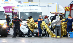 Des rescapés du naufrage d'un taxi-boat tentant de traverser la Manche en couverture de survie sont pris en charge par les secours dans le port de Calais, dans le Pas-de-Calais, le 28 septembre 2026 ( AFP / Sameer AL-DOUMY )