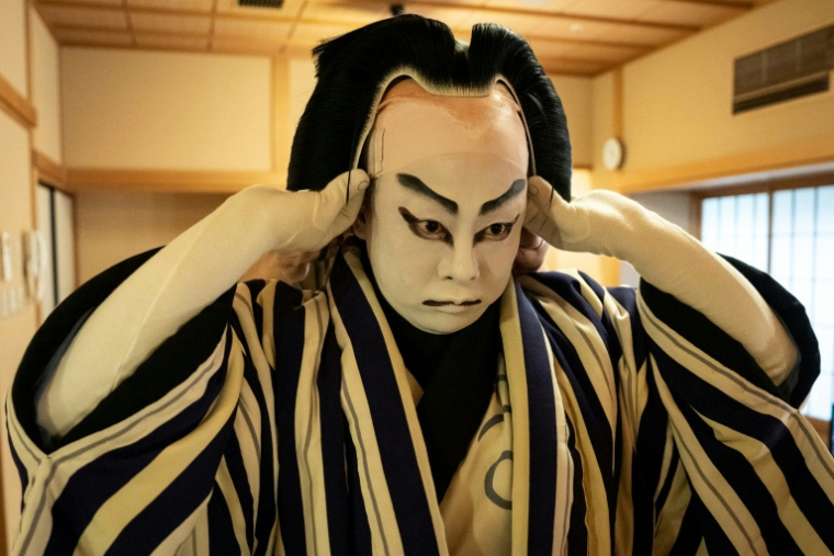 Le maître perruquier Tadashi Kamoji aide l'acteur Tanenosuke Nakamura à mettre sa perruque avant une représentation au théâtre Kabuki-za à Tokyo, le 13 avril 2026 ( AFP / Yuichi YAMAZAKI )
