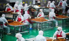 Des ouvriers préparent des lamelles de farine pour les aromatiser avant leur conditionnement à l'usine Mala Wangzi, du comté de Pingjiang, dans la province du Hunan, le 17 juin 2026 dans le centre de la Chine ( AFP / WANG Zhao )