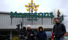 Des personnes passent devant l'entrée d'un magasin Morrisons à Londres
