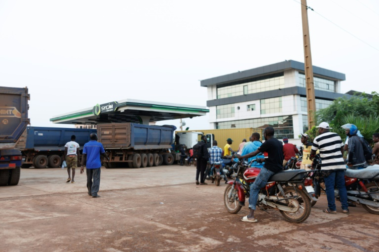Des véhicules et motocyclistes font la queue pour tenter d'obtenir de l'essence à une station dans la capitale malienne Bamako le 7 octobre 2025. Un blocus jihadiste en cours depuis un mois sur le carburant importé des pays voisins provoque des pénuries et commence à perturber fortement ce pays enclavé ( AFP / - )