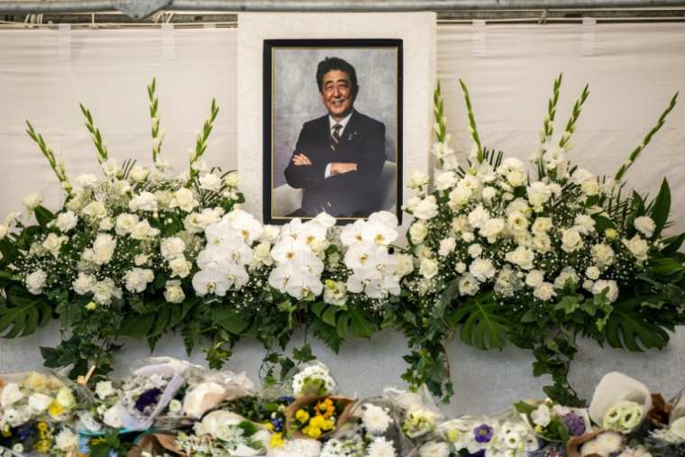 Des fleurs sont déposées sous une photo de l'ancien Premier ministre japonais Shinzo Abe à l'occasion d'une cérémonie dans un temple  un an après sa mort, le 8 juillet 2023 à Tokyo ( AFP / Philip FONG )