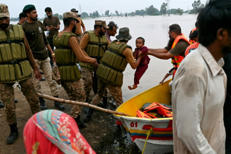 L'armée pakistanaise et des secouristes évacuent en bateau les habitants après après la crue des eaux du fleuve Ravi à Lahore, le 29 août 2025 au Pakistan ( AFP / Arif Ali )