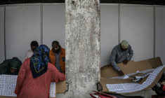 Des électeurs cherchent leur nom sur la liste électorale dans un bureau de vote de Stone Town (Tanzanie), le 29 octobre 2025 ( AFP / MARCO LONGARI )