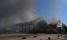 Des policiers et des pompiers travaillent sur un site d'entrepôts endommagés lors d'une frappe militaire russe à Kherson, en Ukraine