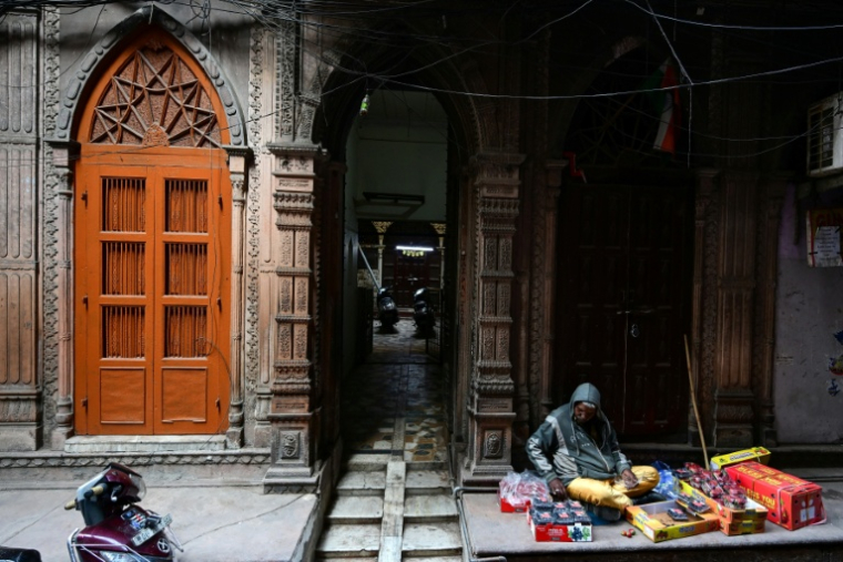 Un vendeur de rue assis devant un haveli centenaire dans le vieux quartier de Delhi, le 5 février 2026 en Inde ( AFP / Manan VATSYAYANA )