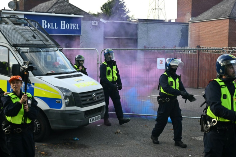 Des fusées éclairantes lancées sur des policiers lors d'une manifestation devant l'hôtel Bell, censé héberger des demandeurs d'asile, à Epping, au nord-est de Londres, le 20 juillet 2025, après que la police a inculpé un demandeur d'asile pour infractions sexuelles ( AFP / JUSTIN TALLIS )