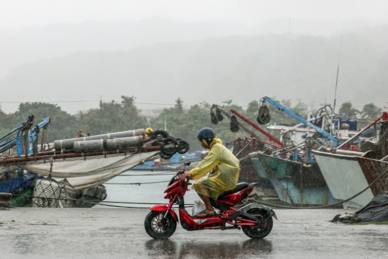 Un homme en scooter sous une pluie battante à Yilan, le 11 novembre 2025, alors que le typhon Fung-Wong approche de Taïan ( AFP / I-Hwa Cheng )