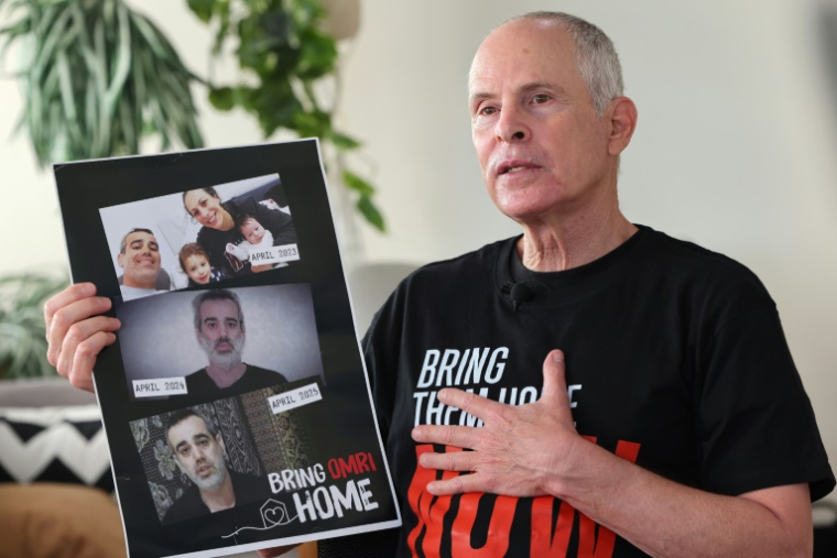 L'Israélo-américain Keith Siegel, qui a passé 484 jours en captivité à Gaza, montre la photo de l'otage Omri Miran avec lequel il a été retenu, lors d'un entretien avec l'AFP, le 12 juin 2025 à Tel-Aviv ( AFP / JACK GUEZ )