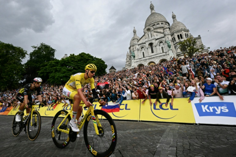Tadej Pogacar (D) et Wout Van Aert devant la basilique du Sacré-Coeur lors de la dernière étape du Tour de France, à Paris, le 27 juillet 2025 ( AFP / Loic VENANCE )