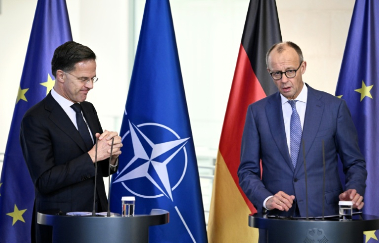 Le chancelier allemand Friedrich Merz (d) et le secrétaire général de l'Otan, Mark Rutte lors d'une conférence de presse à Berlin, le 11 décembre 2025 ( AFP / Tobias SCHWARZ )