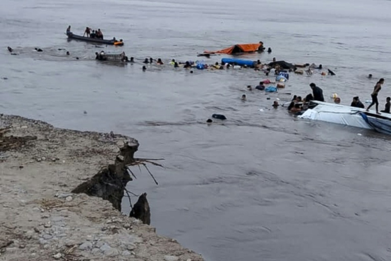 Cette photo diffusée par le Centre régional des opérations d'urgence péruvien montre des personnes autour de l'épave d'un navire impliqué dans un accident mortel survenu le 1er décembre 2025 dans le port d'Iparia, dans la région d'Ucayali, dans la jungle centrale du Pérou ( COER / Handout )