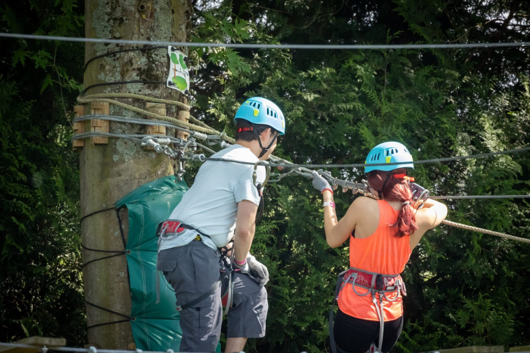 (Crédits photo : Adobe Stock - Deux adolescents évoluant dans les arbres dans un parc accrobranches)
