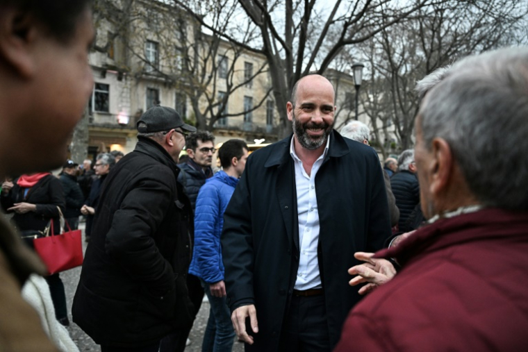 Le communiste Vincent Bouget (C), le 18 mars 2026 à Nîmes où il est candidat à la mairie ( AFP / Gabriel BOUYS )