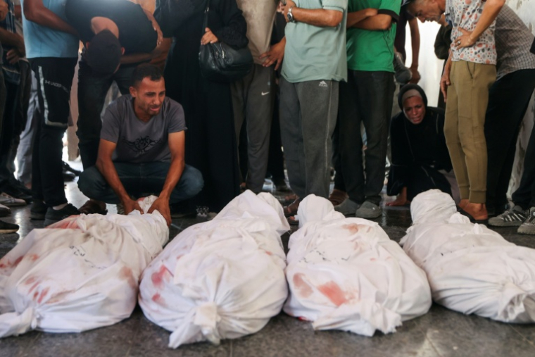 Des Palestiniens pleurent des proches tués par des frappes israéliennes sur le quartier al-Zeitoun, à l'hôpital Baptiste de Gaza-ville, le 19 août 2025 ( AFP / Omar AL-QATTAA )