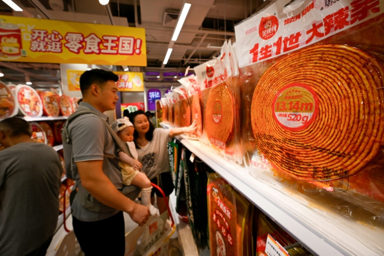 Des clients choisissent des lamelles épicées dans un marché à Changsha, dans la province du Hunan, le 17 juin 2026 dans le centre de la Chine ( AFP / WANG Zhao )