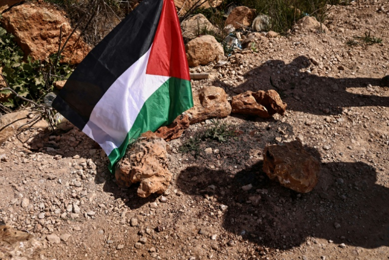 Un drapeau palestinien sur les lieux d'une attaque de colons israéliens qui a coûté la vie à plusieurs Palestiniens dans le village de Abou Falah, au nord-est de Ramallah, le 12 mars 2026 ( AFP / Zain JAAFAR )
