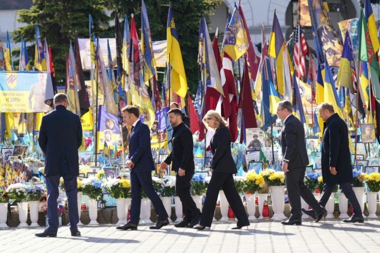 (g-d) Le chancelier allemand Friedrich Merz, le président français Emmanuel Macron, le président ukrainien Volodymyr Zelensky, son épouse Olena Zelenska, le Premier ministre britannique Keir Starmer et le Premier ministre polonais Donald Tusk rendent hommage aux victimes de la guerre au Mémorial des morts de la place de l'Indépendance (Maidan) à Kiev, le 10 mai 2025 ( POOL / Stefan Rousseau )