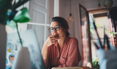 une femme réfléchit devant un ordinateur (Crédits: Adobe Stock)