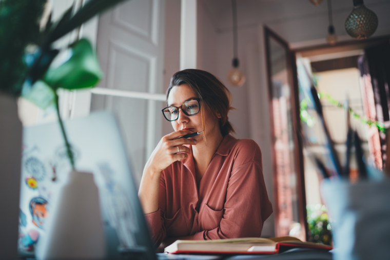 une femme réfléchit devant un ordinateur (Crédits: Adobe Stock)