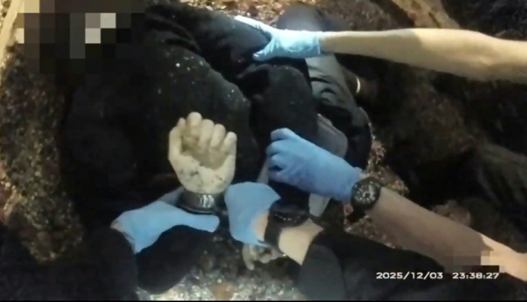 Capture d'écran d'une vidéo, datant du 3 décembre 2025 et diffusée par la police le 2 juin 2026, montrant un jeune homme poignardé, menotté par des agents à  Southampton, dans le sud de l'Angleterre ( Hampshire & Isle of Wight Constabulary / - )